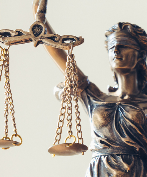 Close-up of a Lady Justice statue holding scales, representing impartiality and fairness.